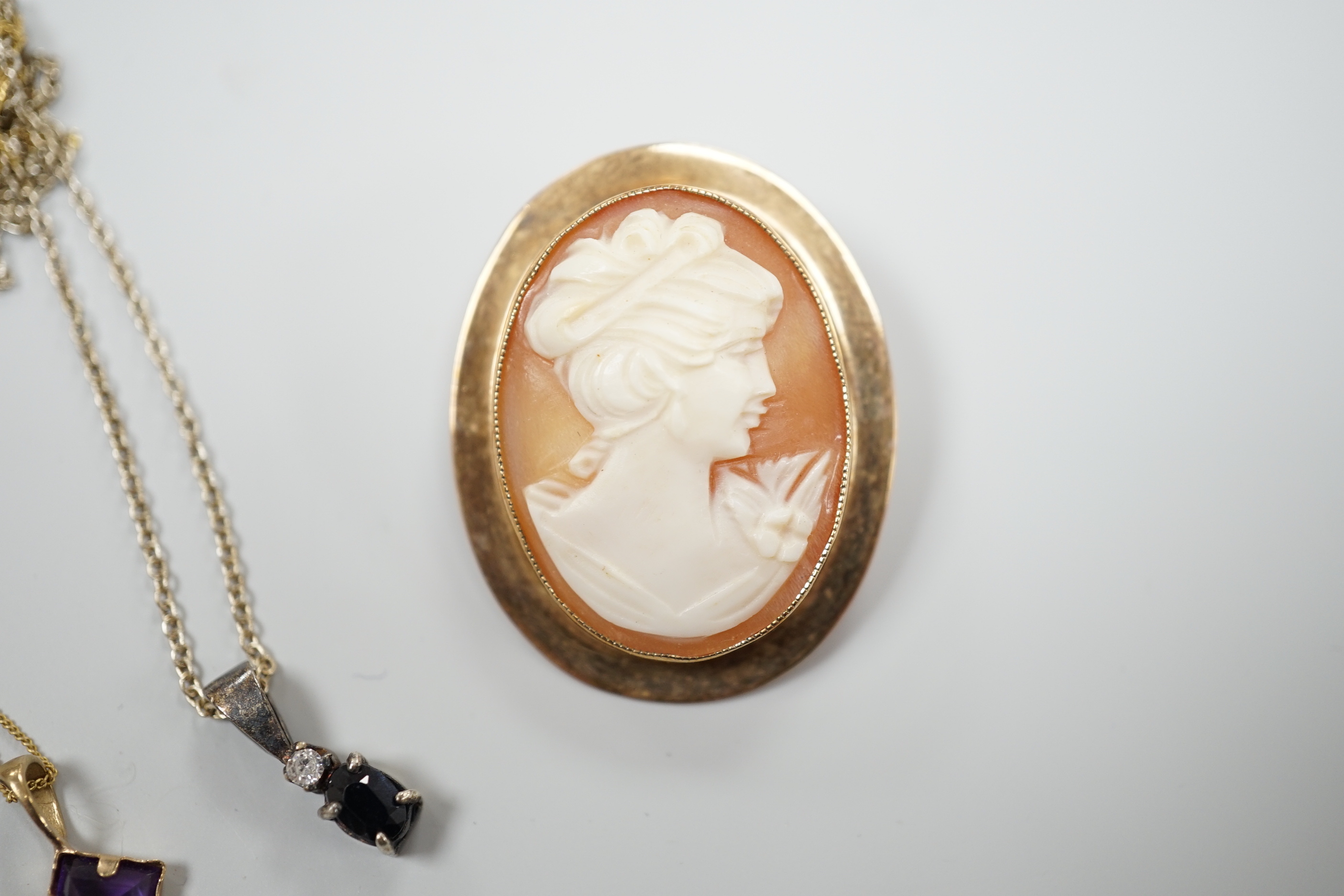 A modern 9ct gold mounted oval cameo shell brooch and two pendant necklaces including one 9ct.